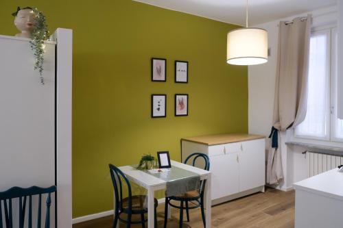 a dining room with a table and a green wall at Residence Ferraud in Pinerolo