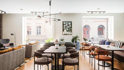 a restaurant with tables and chairs in a room at Home Hotel Grand Sundsvall in Sundsvall