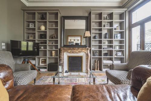 un salon avec une cheminée et une télévision dans l'établissement L'Élégance Vue Parc, à Reims