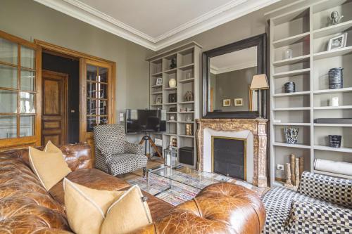 un salon avec un canapé et une cheminée dans l'établissement L'Élégance Vue Parc, à Reims