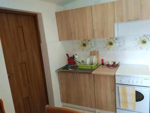 a kitchen with wooden cabinets and a white stove top oven at Agroturystyka u Darka in Kolno