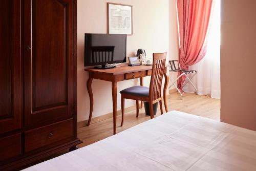 a bedroom with a desk with a computer and a chair at Certosa di Pontignano Residenza d'Epoca - Place of Charme in Ponte A Bozzone