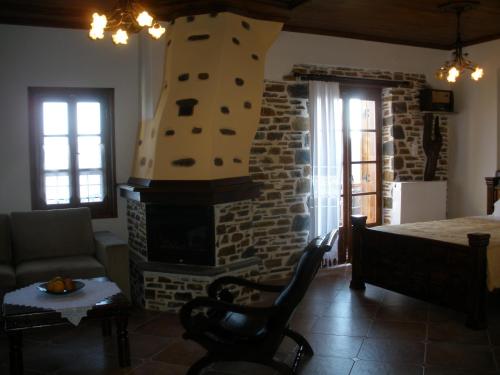 a living room with a fireplace and a bed at Seirios in Vizitsa