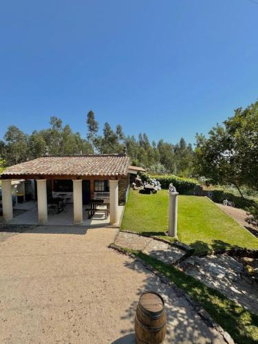 a pavilion with a picnic table in a park at O Moinho de Vale da Mó in Anadia