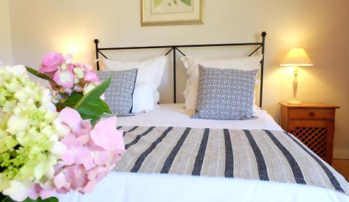 a bedroom with a bed with blue and white pillows at Vine Guesthouse in Stellenbosch