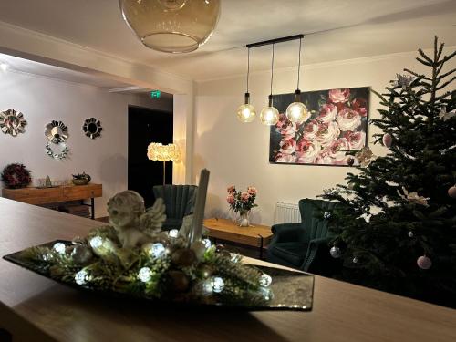 a living room with a christmas tree and a table at Pensiunea NOVO in Baile Felix