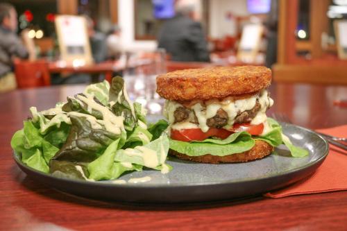a sandwich and a salad on a plate on a table at Brit Hotel Agen - L'Aquitaine in Le Passage