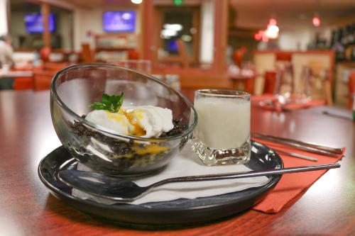 a bowl of ice cream and a glass of milk on a table at Brit Hotel Agen - L'Aquitaine in Le Passage