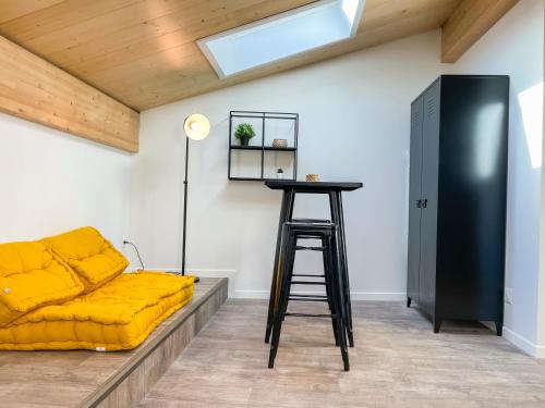 ein Wohnzimmer mit einem gelben Sofa und einem Stuhl in der Unterkunft Beau Studio lumineux avec Climatisation pour 2 Personnes in Bordeaux