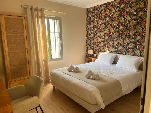 a bedroom with a large bed with a floral wall at Maison d'hôtes à Laplume in Laplume