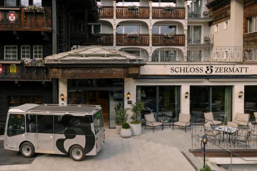 a golf cart parked in front of a building at SCHLOSS Zermatt - CBD & Adaptogenic Spa and Sport Hotel in Zermatt