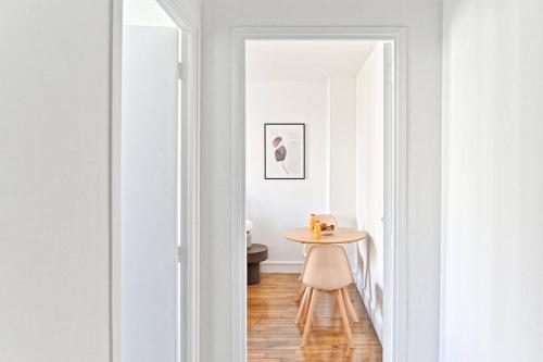 un couloir avec une petite table et une chaise dans l'établissement Studio fashion Proche Métro #Paris #Montreuil, à Montreuil