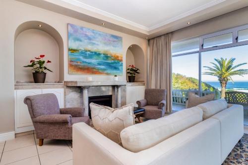 a living room with a couch and a fireplace at Hermanus Beachfront Lodge - Solar Power in Hermanus