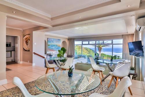 a living room with a glass table and chairs at Hermanus Beachfront Lodge - Solar Power in Hermanus