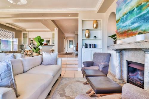 a living room with a couch and a fireplace at Hermanus Beachfront Lodge - Solar Power in Hermanus