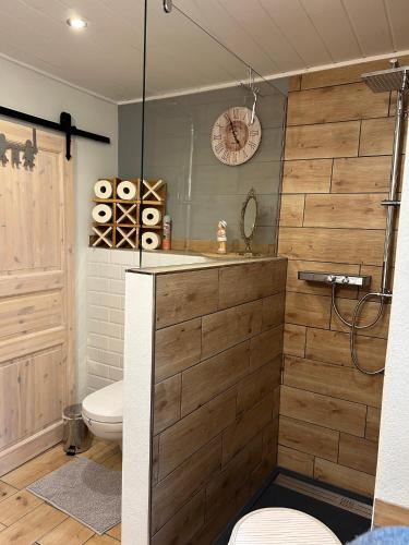 a bathroom with a toilet and a clock on the wall at Ferienhaus Klaus in Kirchenlamitz