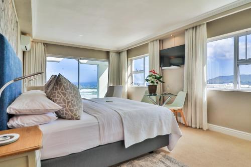 a bedroom with a bed with a view of the ocean at Hermanus Beachfront Lodge - Solar Power in Hermanus