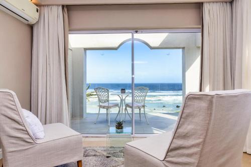a living room with a view of the ocean at Hermanus Beachfront Lodge - Solar Power in Hermanus