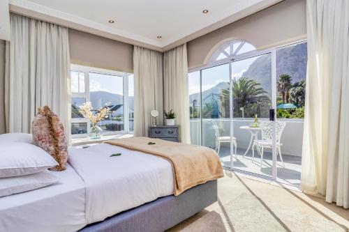 a bedroom with a bed and a large window at Hermanus Beachfront Lodge - Solar Power in Hermanus