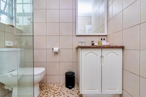 a bathroom with a toilet and a sink at Hermanus Beachfront Lodge - Solar Power in Hermanus
