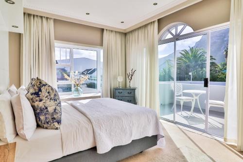 a bedroom with a large bed and a balcony at Hermanus Beachfront Lodge - Solar Power in Hermanus