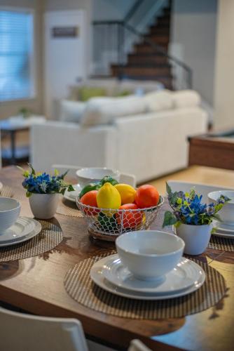 a table with bowls of fruit and plates on it at Pool, Gameroom & Minigolf Enchanting Texas Home in San Antonio