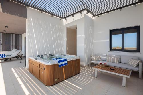 a bathroom with a sink and a couch at Paoma Luxury Beach Suite with jacuzzi in Podstrana