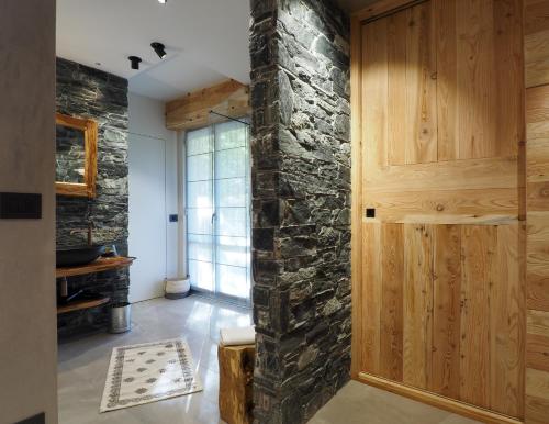 a room with a stone wall and a wooden door at Hotel della valle in Vernante