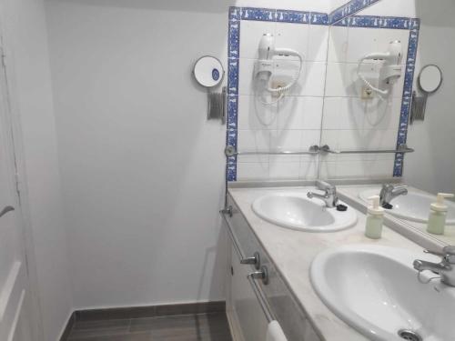 a bathroom with two sinks and a mirror at Sonsoles Apartamentos Bahía Sur in San Fernando
