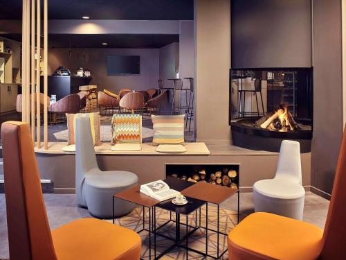 a restaurant with a fireplace in the middle of a room at Mercure Paris Sud Les Ulis-Courtaboeuf in Les Ulis