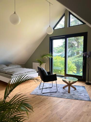a bedroom with a bed and a chair and a table at Huus Bellevue in Gleisweiler