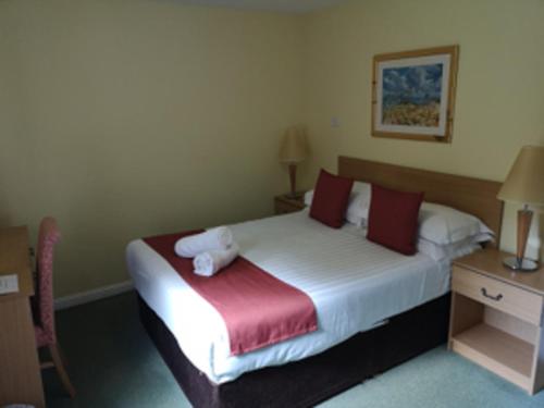 a hotel room with a bed with a teddy bear on it at Bridge of Cally Hotel in Blairgowrie