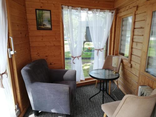 a room with a chair and a table and a window at Sommerferienhaus Jeannette in Strausberg