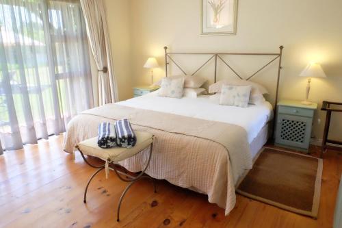 a bedroom with a large bed and a table at Vine Guesthouse in Stellenbosch