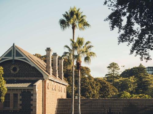 a brick building with palm trees in front of it at The Sebel Kiama in Kiama