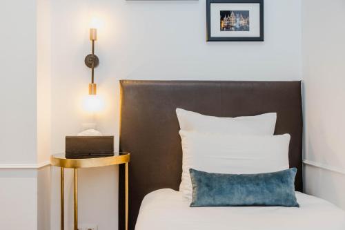 a bed with a black headboard and a blue pillow at Boutique hotel Maison Emile in Antwerp