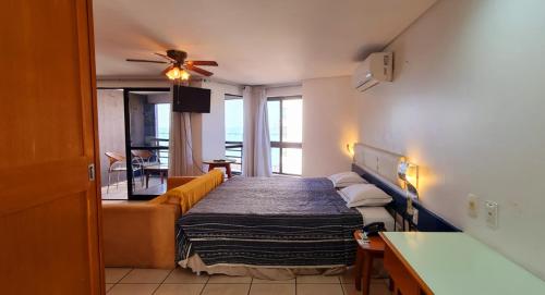 a hotel room with a bed and a couch at Flat no Iate Plaza Hotel in Fortaleza