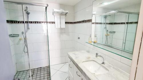 a bathroom with a shower and a sink and a mirror at Flat no Iate Plaza Hotel in Fortaleza