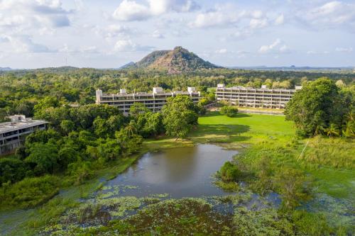 an aerial view of a building and a river with a mountain at Jetwing Lake in Dambulla