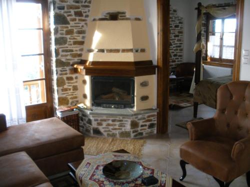 a living room with a stone fireplace in a living room at Seirios in Vizitsa