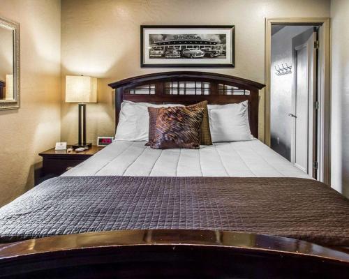 a bedroom with a large bed with a wooden headboard at Rodeway Inn & Suites Williams Downtowner-Rte 66 in Williams