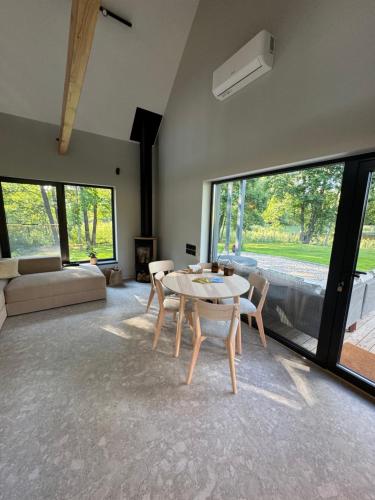 a living room with a table and chairs and a couch at Lavender Resort in Molėtai
