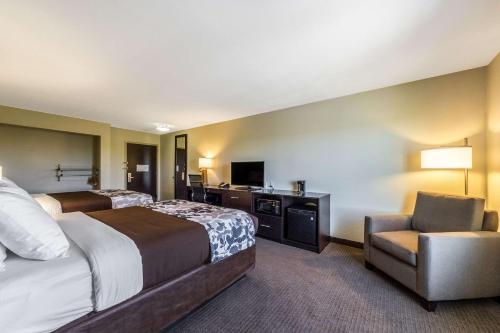 a hotel room with a bed and a chair at Sleep Inn & Suites in Pleasanton