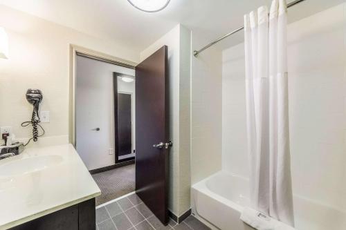 a bathroom with a sink and a tub and a shower at Sleep Inn & Suites in Pleasanton