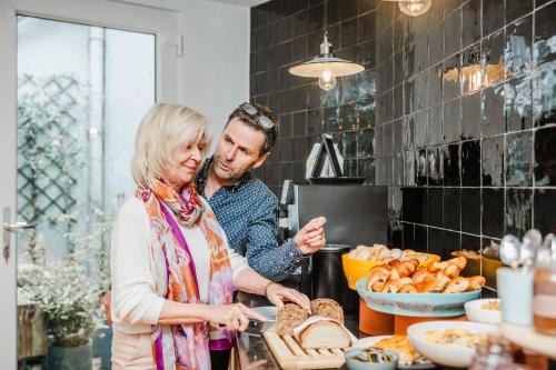 a man and a woman preparing food in a kitchen at Boutique hotel Maison Emile in Antwerp