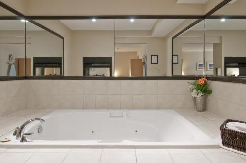 a large bathroom with a tub with a large mirror at Travelodge by Wyndham Trenton in Trenton