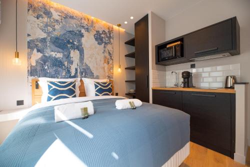 Cet appartement comprend une chambre avec un grand lit bleu et une cuisine. dans l'établissement Demeure Montmartre, à Paris