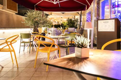 a restaurant with tables and chairs and an umbrella at Adesso Hotel in Rome