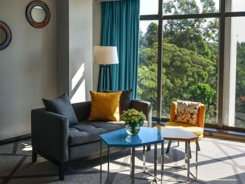 a living room with a couch and a table at Novotel Nairobi Westlands in Nairobi