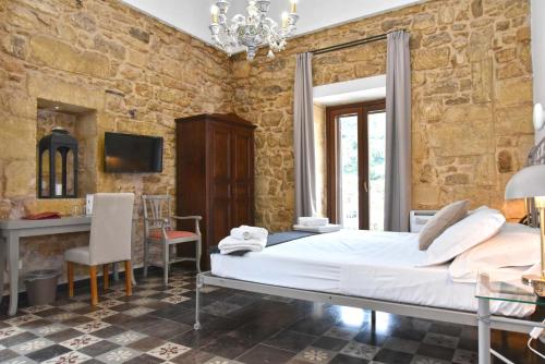 a bedroom with a bed and a table and chairs at Itria Palace in Ragusa